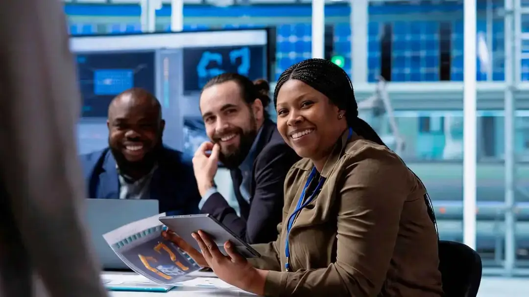 Três pessoas sentadas olhando em sua direção e sorrindo