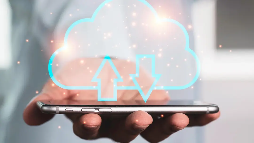 Mão segurando um celular com uma ilustração de nuvem para representar expansão